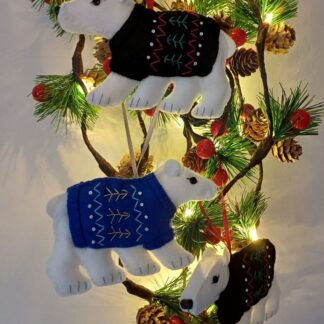 Polar bears with black and royal blue embroidered jumpers felt Christmas tree hanging decorations by lyndawilcansew hung on a green foliage garland