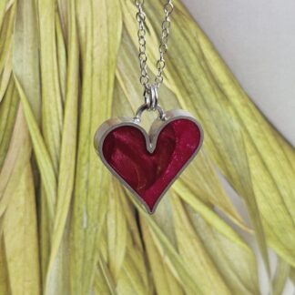 Handmade sterling silver heart pendant, inlayed with resin and polymer clay, in shades of winterberry crimson red