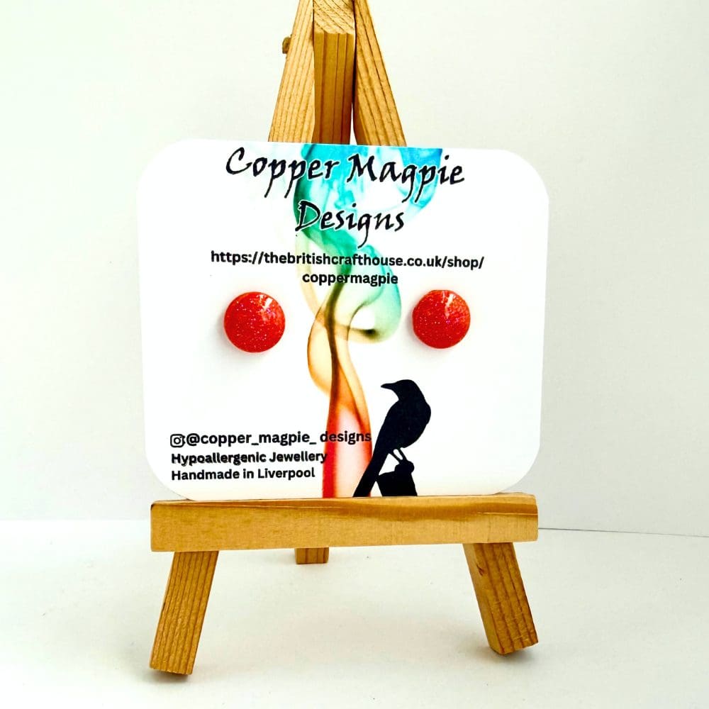 Cute sparkly orange round studs on surgical steel backs displayed on a Copper Magpie Designs jewellery card.