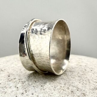 Textured 925 Sterling Silver Spinner Meditation Ring sitting on a stone