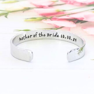 a hammered texture 9mm aluminium cuff bracelet with the words Mother of the Bride or Groom hand-stamped inside along with the date of the wedding