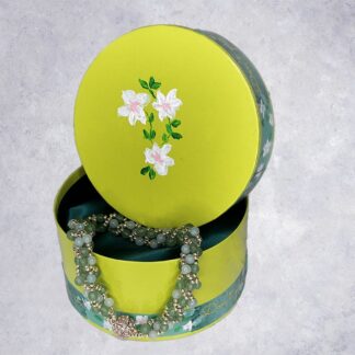 Amazonite and aventurine beadwork bracelet draped over side of up cycled gift box decorated in mixed media