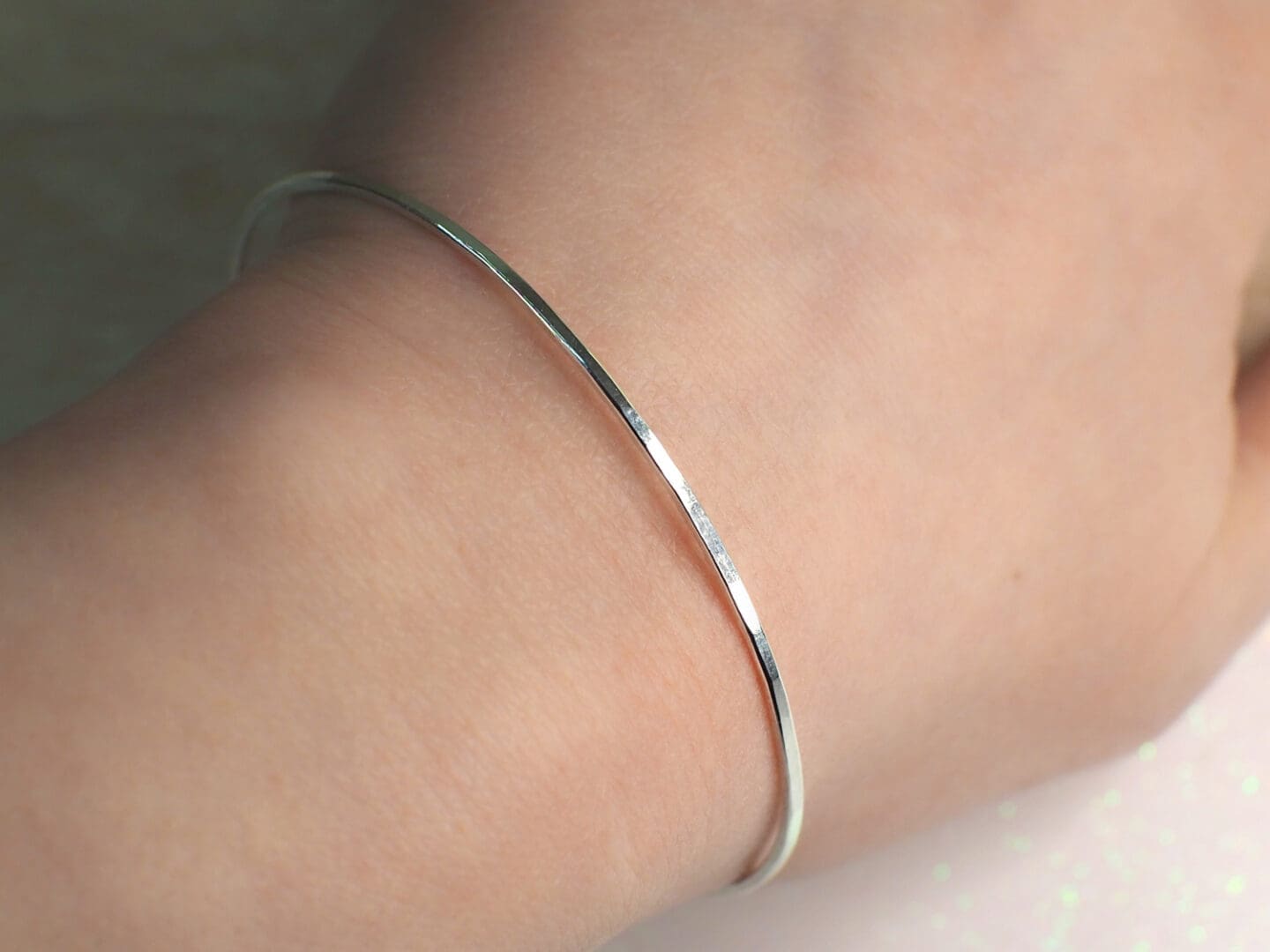 skinny silver bangle on a womans wrist