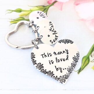 aluminium heart keyring hand-stamped with 'this Nanny is loved by' with flower detailing and personalised name tags