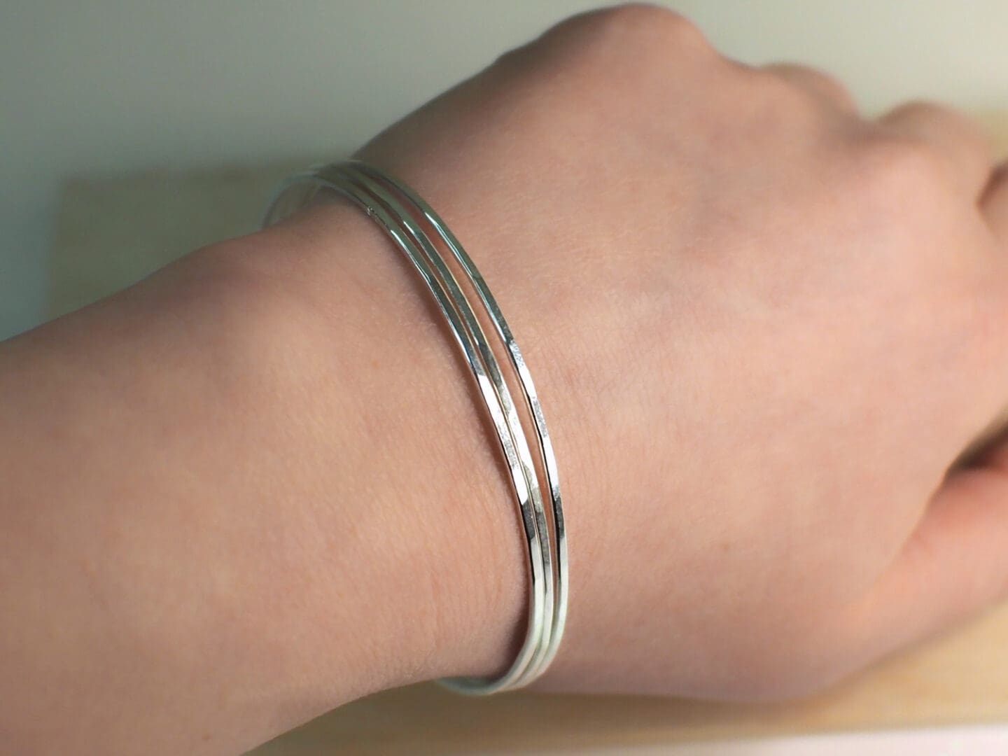 silver bangles on womans wrist