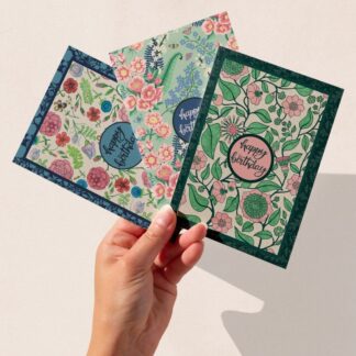 Set of three botanical birthday cards with floral patterns and “Happy Birthday” lettering, hand-illustrated by The Illustrarium.