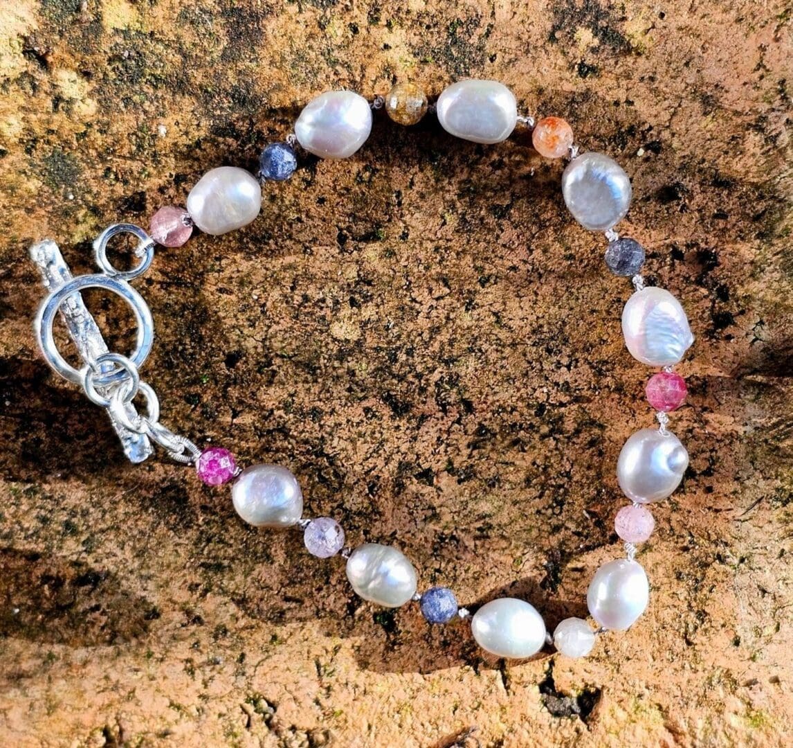 Grey baroque pearl, ruby & sapphire gemstone bead bracelet, outdoor shot, Isobel Kelly Jewellery