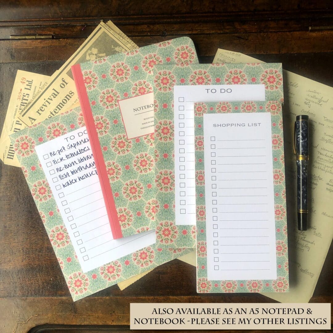 A flat lay of matching floral stationery including a shopping list, to-do list, and notebook in a daisy pattern, styled with vintage letters and a pen.