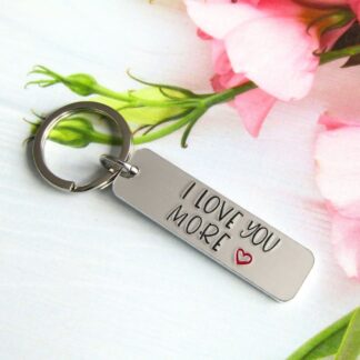 A hand-stamped aluminium rectangular keyring with I love you more hand-stamped on it