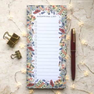 Shopping list notepad with a hand-painted vintage fashion design of bags and accessories, styled with a red pen, gold clips and fairy lights.