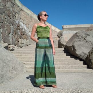 woman wearing wide leg green trousers and sparkling green cami top
