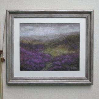 Moody moorland scene with heavy grey rain clouds over distant hills and purple heather in bloom in the foreground.