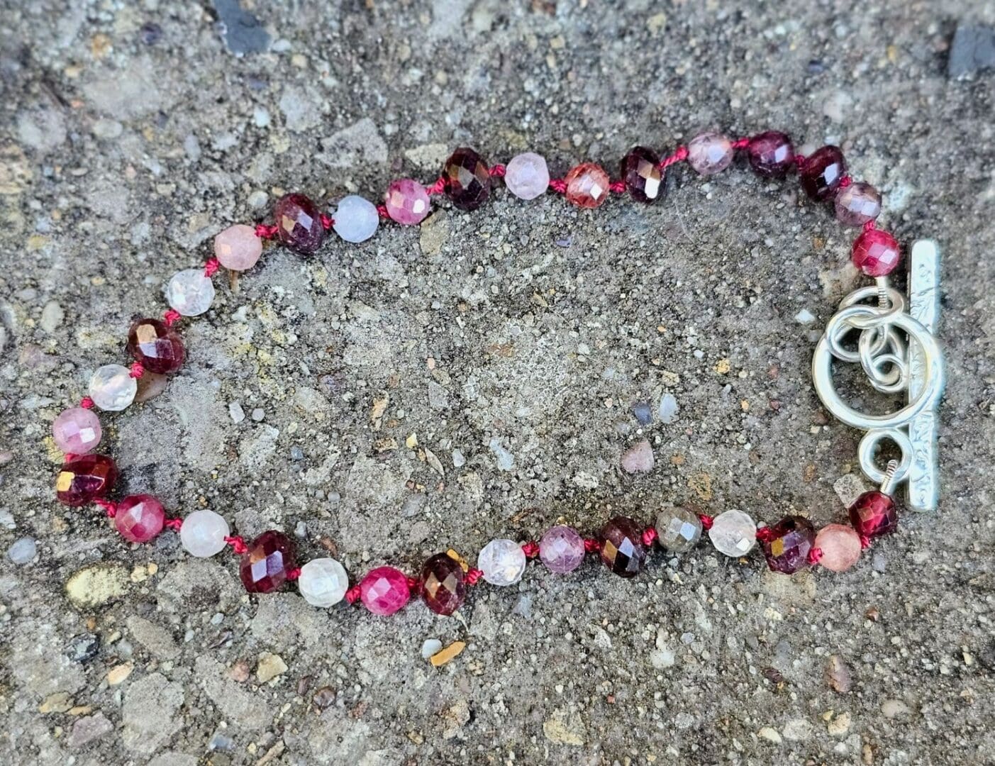 Spinel and garnet gemstone bracelet, outdoor stone shot, Isobel Kelly Jewellery