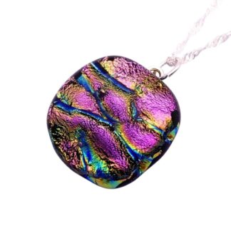 A vibrant pendant with cracked textures in iridescent shades of purple, pink, green and blue hangs on a silver chain. The tone is colorful and artistic.