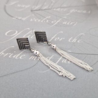Sterling silver diamond shaped Art Deco style studs, with an oxidised chevron pattern and tassels suspended from them.