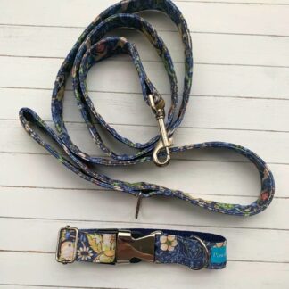 Flat lay photo of dog collar and partially coiled lead in navy William Morris Strawberry Thief design
