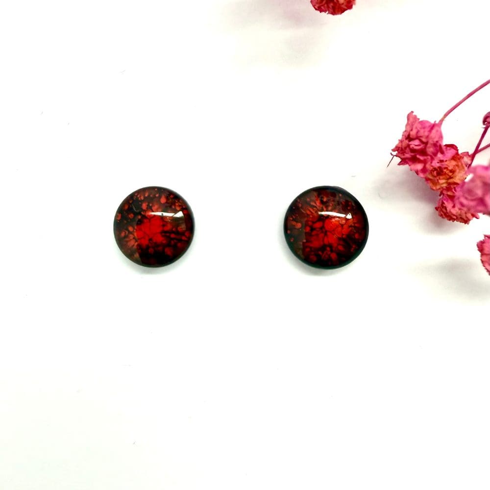 Handmade red resin stud earrings showing crackle alcohol ink texture.