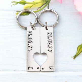 a set of 2 rectangle keyrings with a heart cut-out featuring personalised anniversary dates and initials