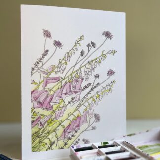 Greeting card with pink flowers running diagonally across the front. Featuring pink foxgloves, standing in front of a box of paints.