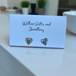 Silver heart shaped earrings on a white countertop