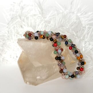 Beadwork bracelet in mixed gemstone beads draped on a rock