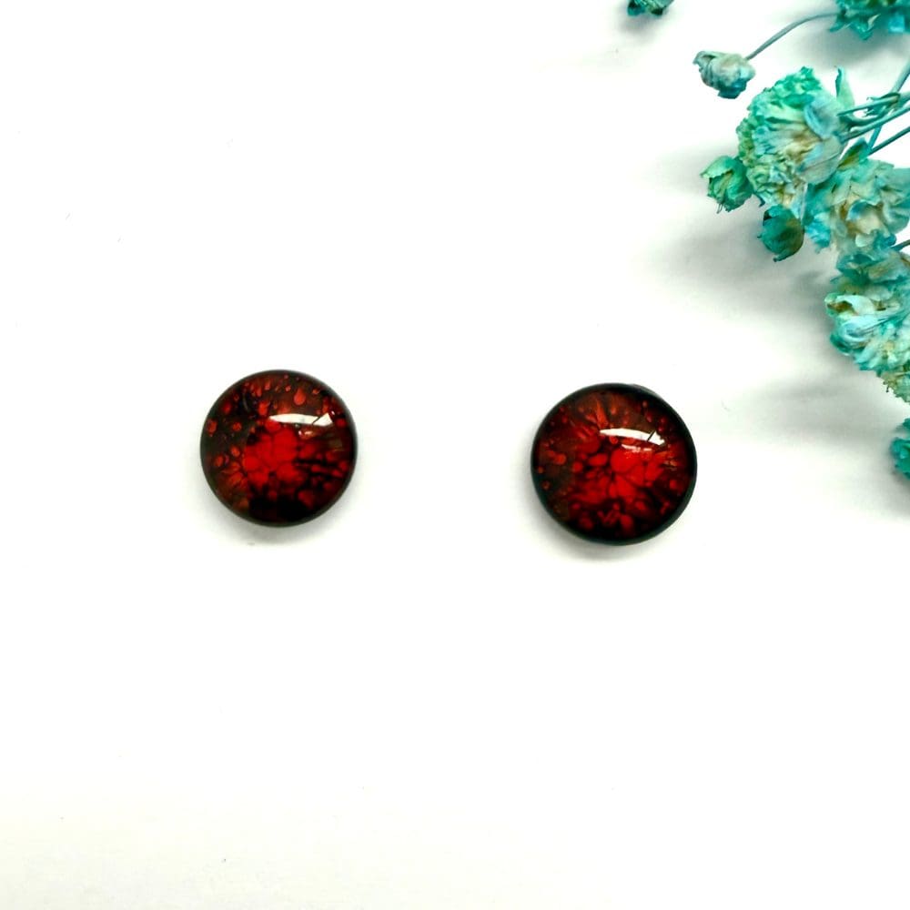 Fiery red resin earrings displayed to show glossy dome finish.