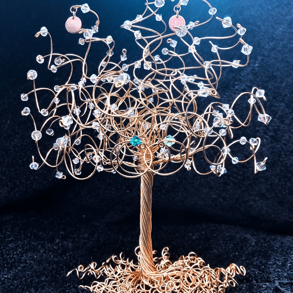 Gold wire tree with crystals decorating the branches and two engraved name charms hanging off two upper branches.