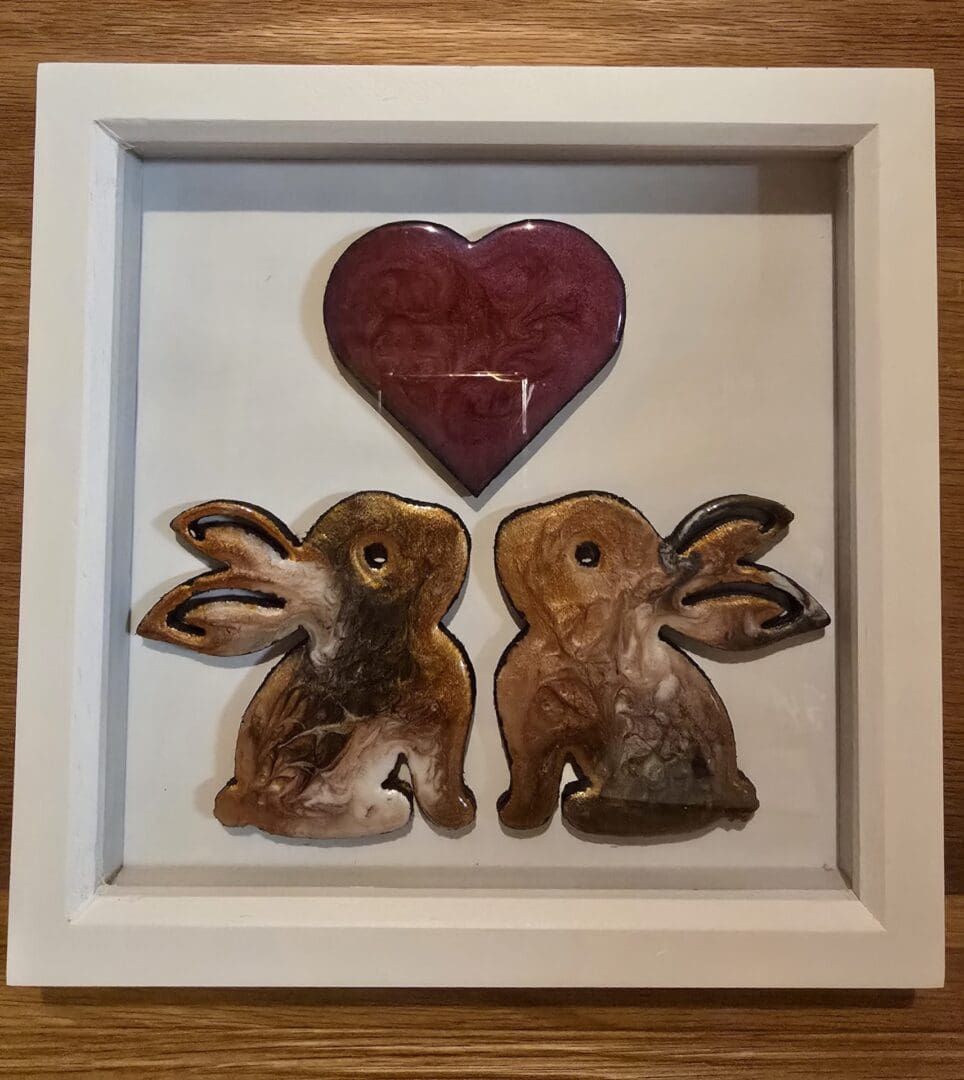 Framed resin rabbit artwork with two rabbits beneath a red heart.