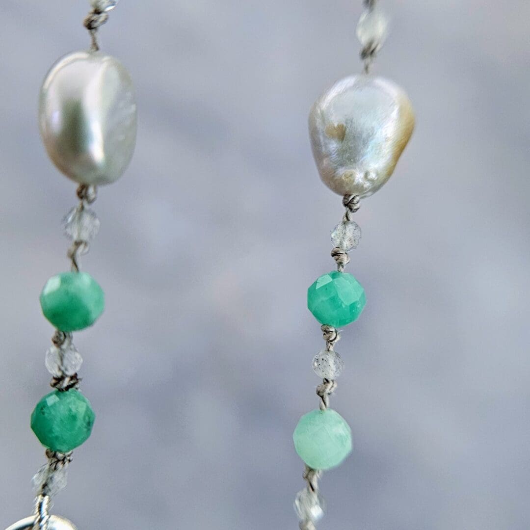 Etched sterling silver ivy pendant set with white sapphires, tsavorite garnets and lab emeralds, strung on a silk necklace with emerald, labradorite and baroque pearls. Bead details. Isobel Kelly Jewellery, Hants UK