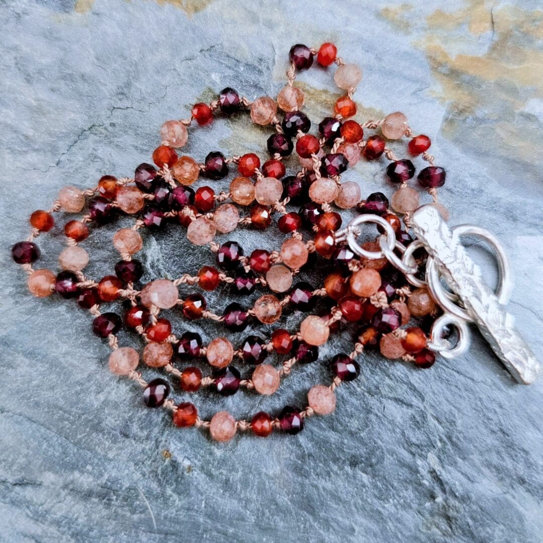 Garnet, sunstone and carnelian gemstone necklace, etched silver toggle, coiled beads, Isobel Kelly Jewellery