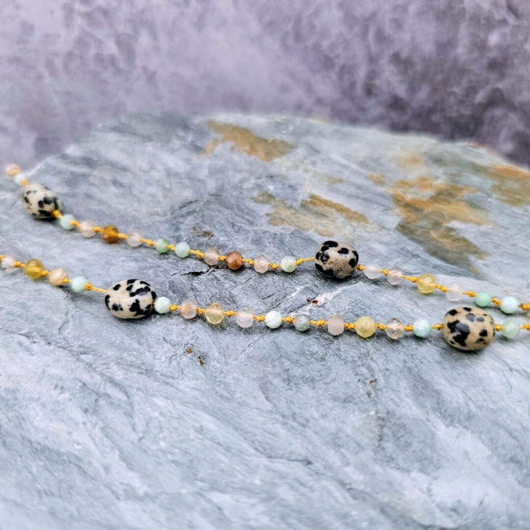 Chrysoprase, yellow opal, rutilated quartz, Dalmatian jasper knotted strand, silver toggle, flat grey background, Isobel Kelly Jewellery
