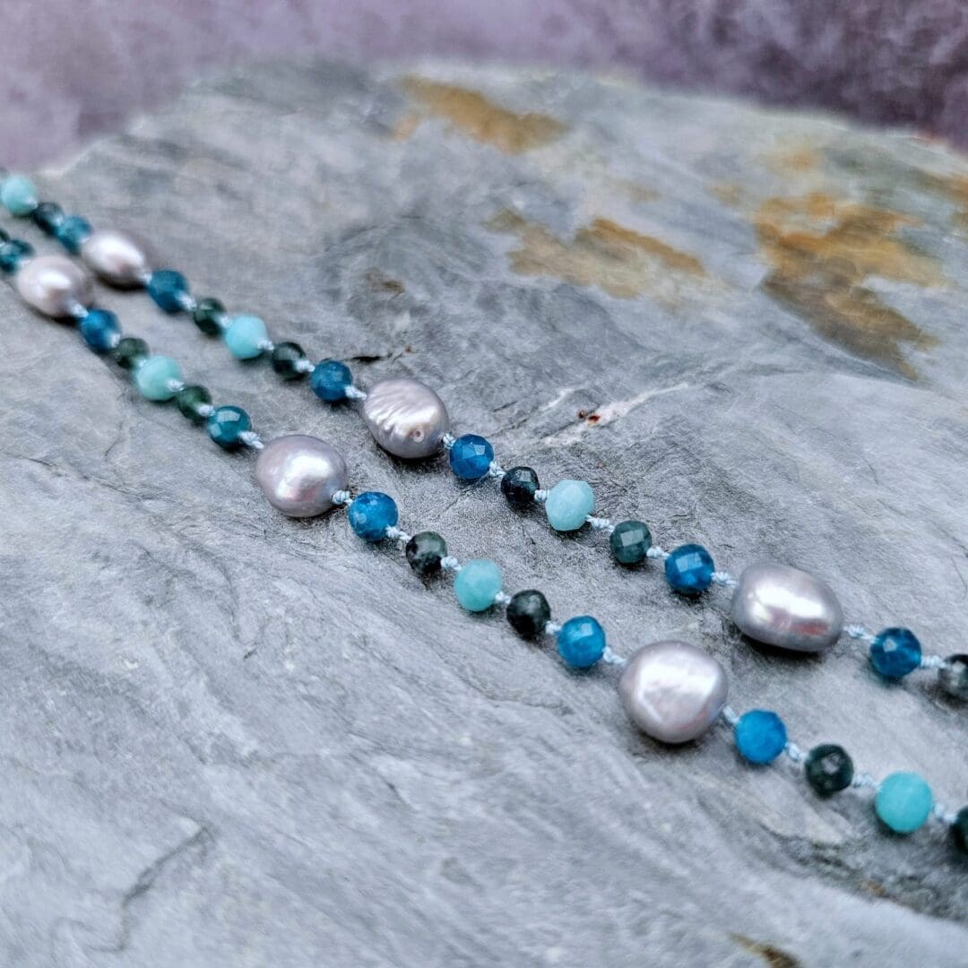 Grey baroque pearl, blue tourmaline, apatite and amazonite, flat grey background, Isobel Kelly Jewellery