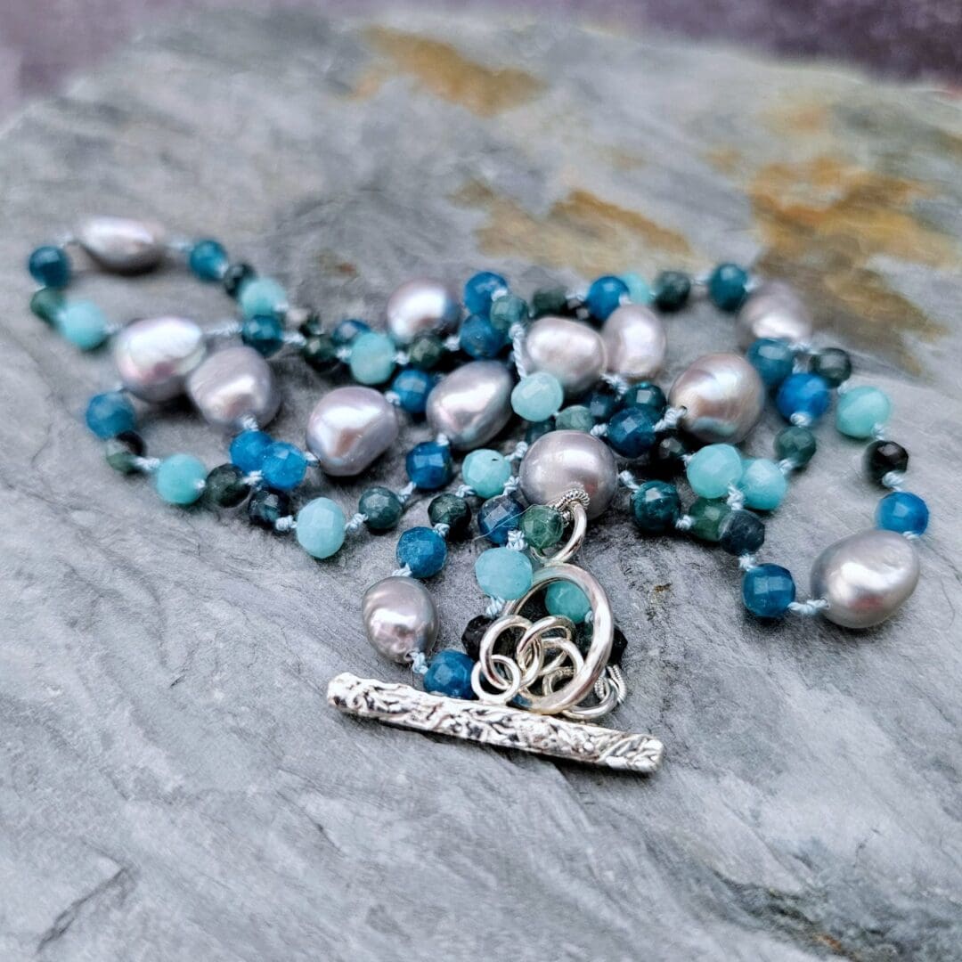Grey baroque pearl, blue tourmaline, apatite and amazonite, bead and toggle grey background, Isobel Kelly Jewellery