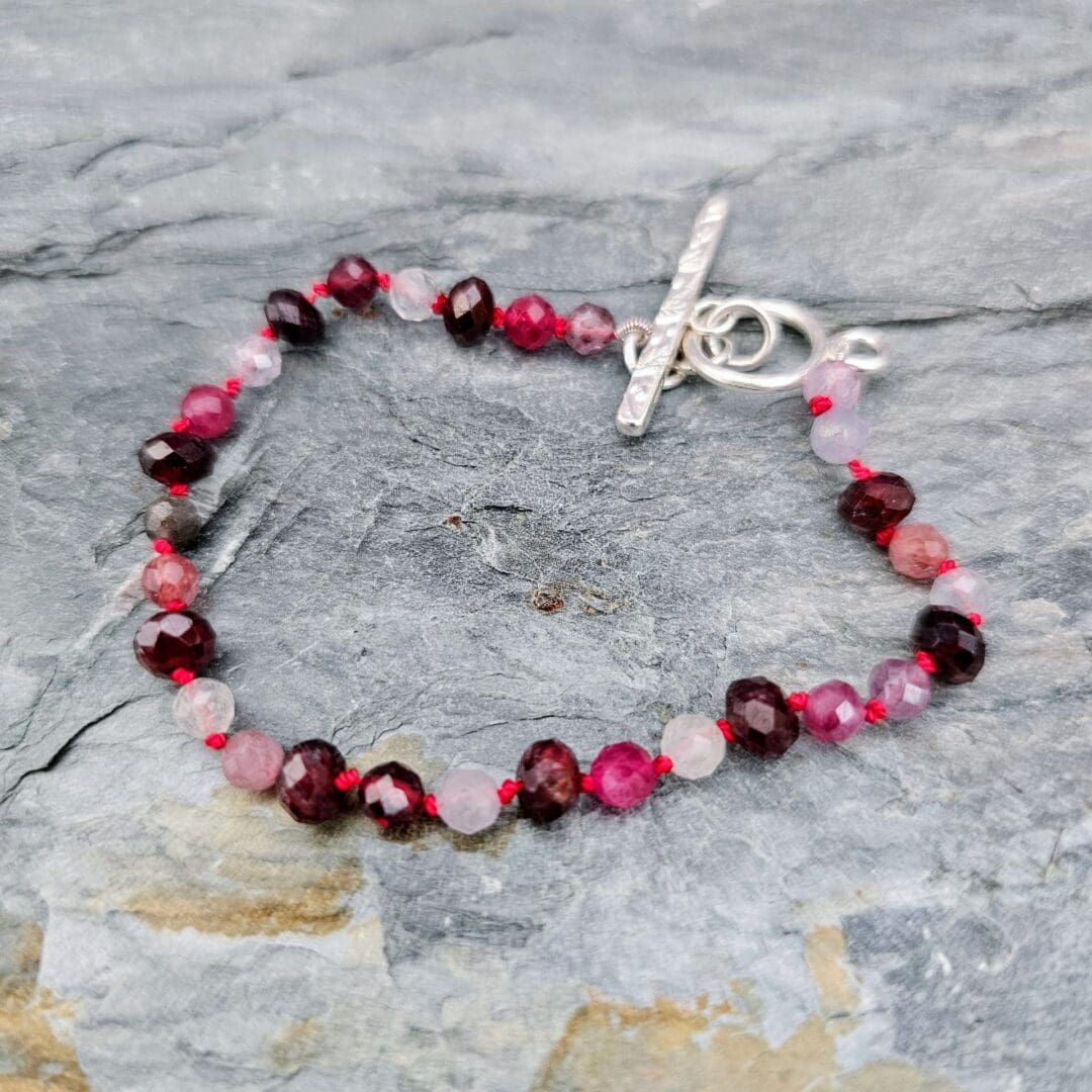 Spinel and garnet gemstone bracelet, grey background full, Isobel Kelly Jewellery