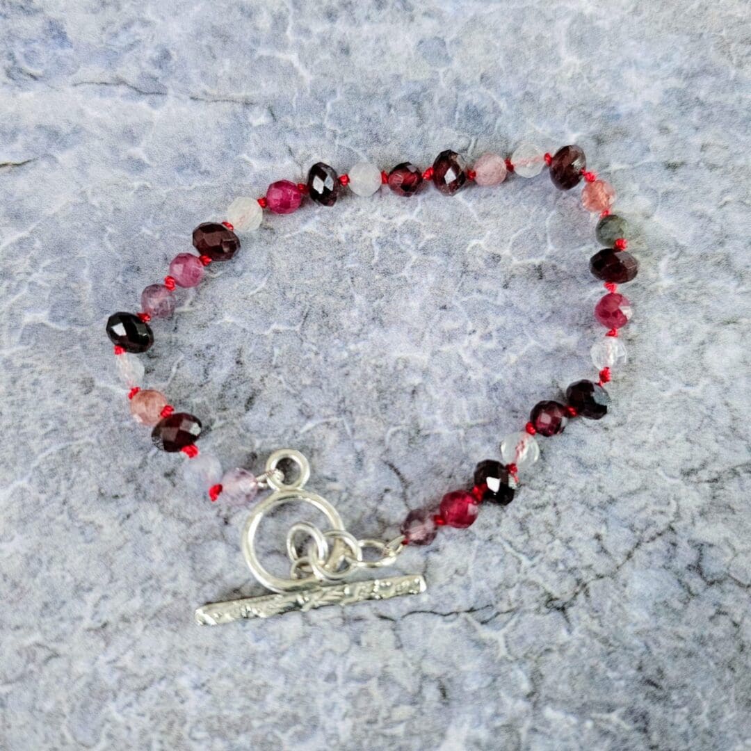 Spinel and garnet gemstone bracelet, grey background top, Isobel Kelly Jewellery