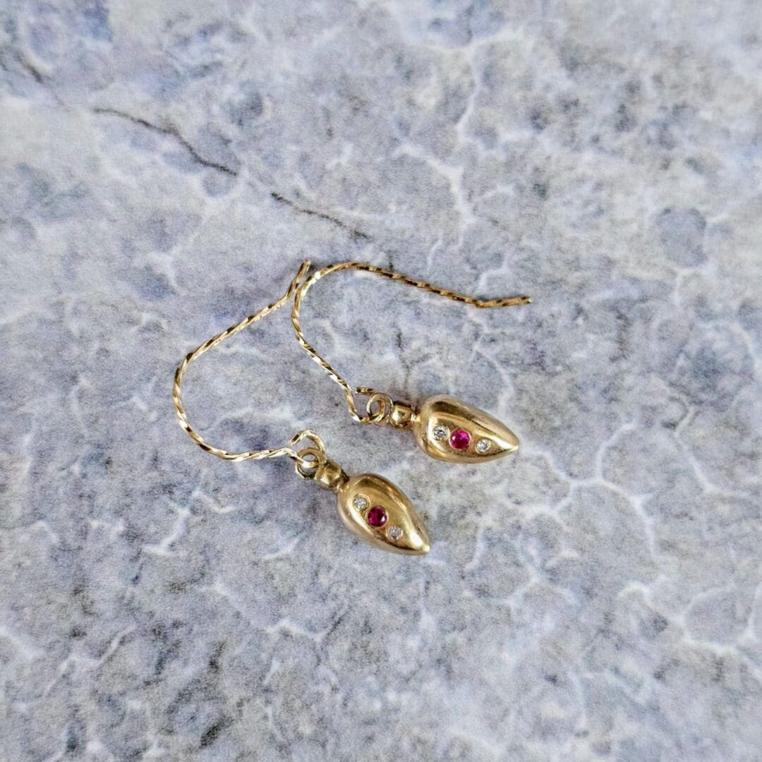 9ct gold drop earrings inspired by Roman amphora vessels, set with lab-grown diamonds and a central pink ruby, featuring twisted gold hooks. Top view. Isobel Kelly Jewellery, Hants UK