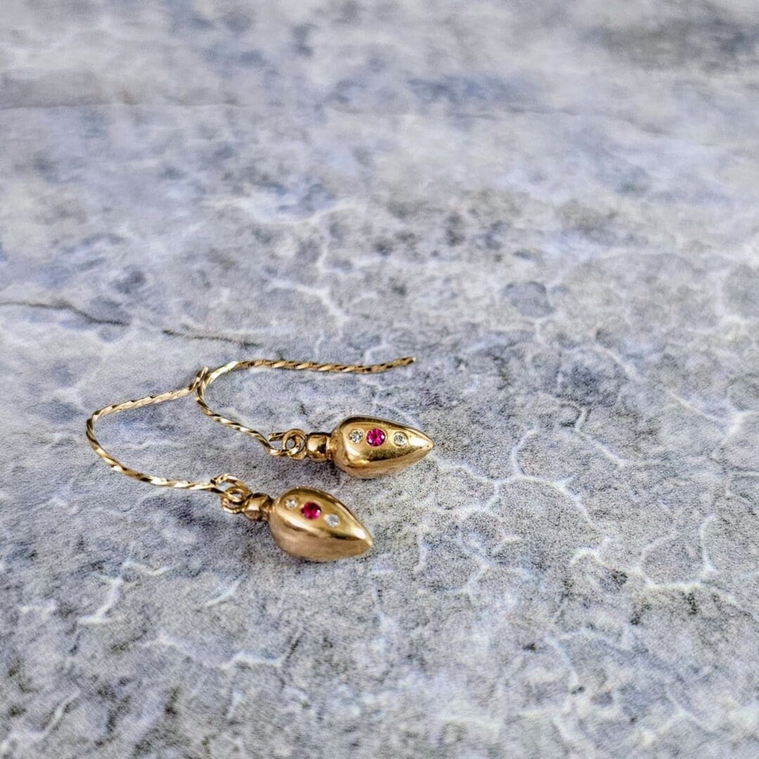 9ct gold drop earrings inspired by Roman amphora vessels, set with lab-grown diamonds and a central pink ruby, featuring twisted gold hooks. Isobel Kelly Jewellery, Hants UK