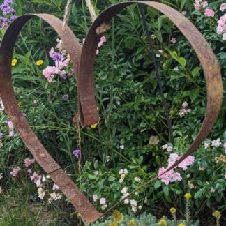 rusty metal garden heart made from a whisky barrel hoop