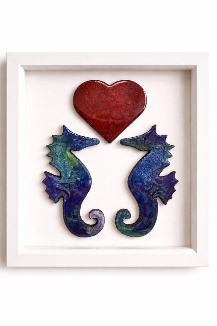 Handcrafted resin wall art of two seahorses beneath a red heart in a matt white box frame.
