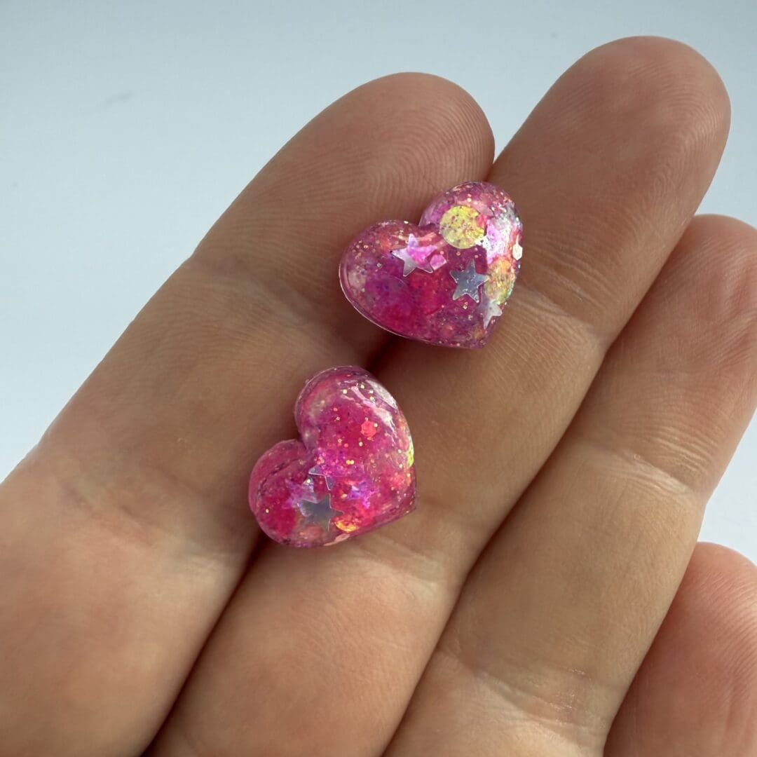 Small pink heart earrings with embedded star glitter