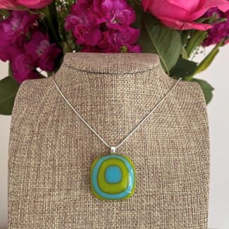 A bright and bold square boho style fused glass pendant in alternating squares of turquoise and lime green. On sterling silver chain or faux suede