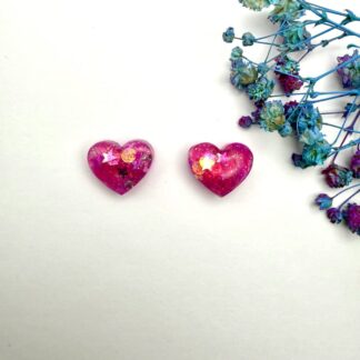 Pink glitter resin jewellery with romantic heart design. Displayed on a white background.