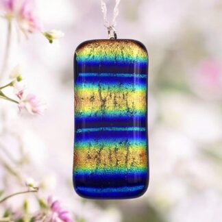 A vibrant pendant features blue, gold, and green stripes set against a soft floral background, showcasing its shimmering, textured surface.