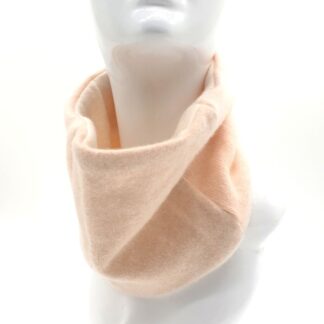 Model wearing neck warmer in shades of cream