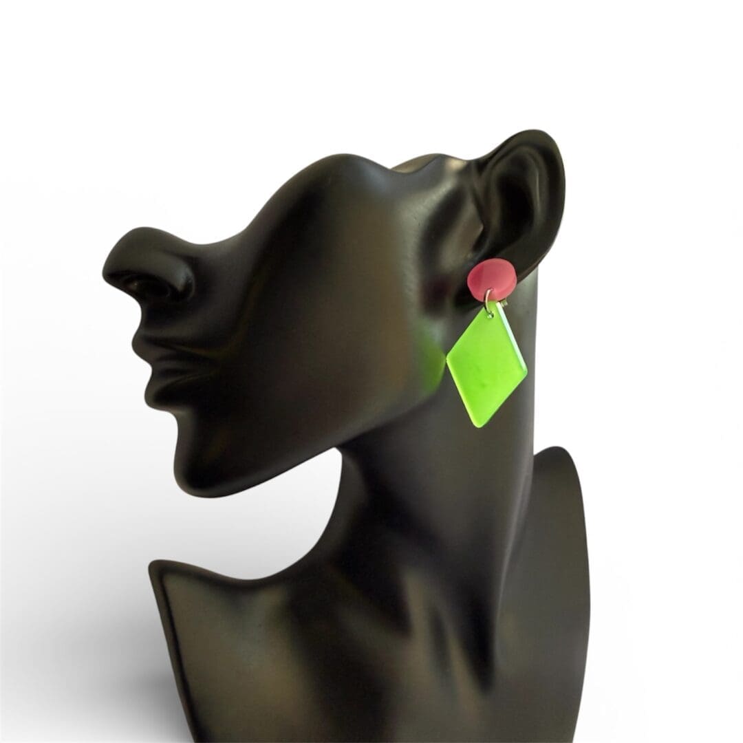 Colourful handmade resin earrings inspired by science and neon aesthetics displayed on a bust.