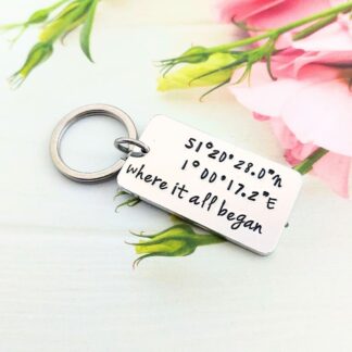 A hand-stamped keyring with personalised coordinates added with the wording where it all began at the bottom