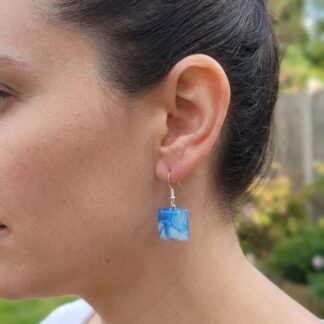 handpainted-earrings-blue-and-white-sweetpea-designs-sarah-tysall-ocean-worn-by-a-woman