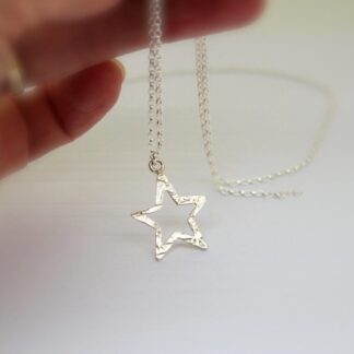 Textured sterling silver star pendant held on silver belcher chain