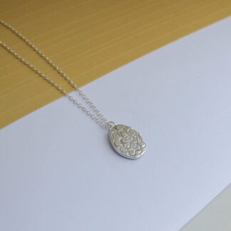 Silver oval shaped patterned pendant