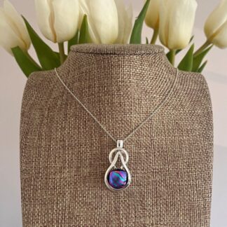 Multicoloured blue, pink and purple dichroic glass on a celtic knot style pendant. With sterling silver chain